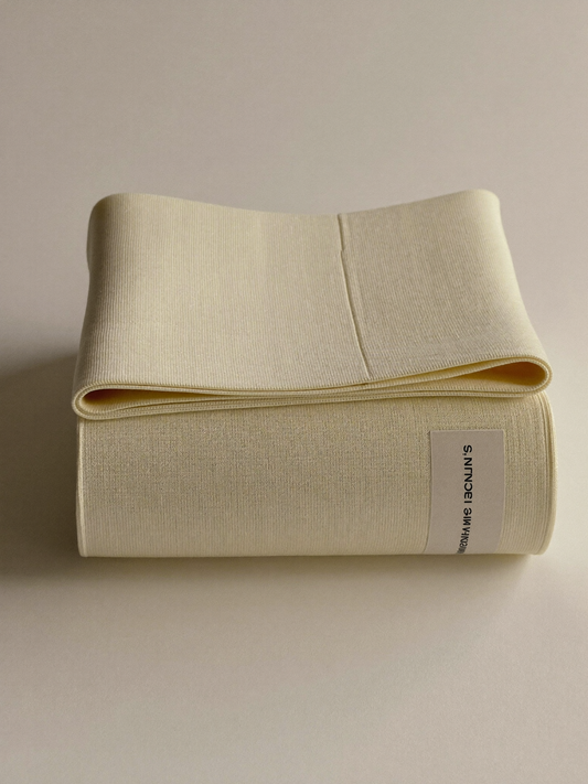 PLACEHOLDER (AI-generated) - Rolled cream postpartum support band on cream