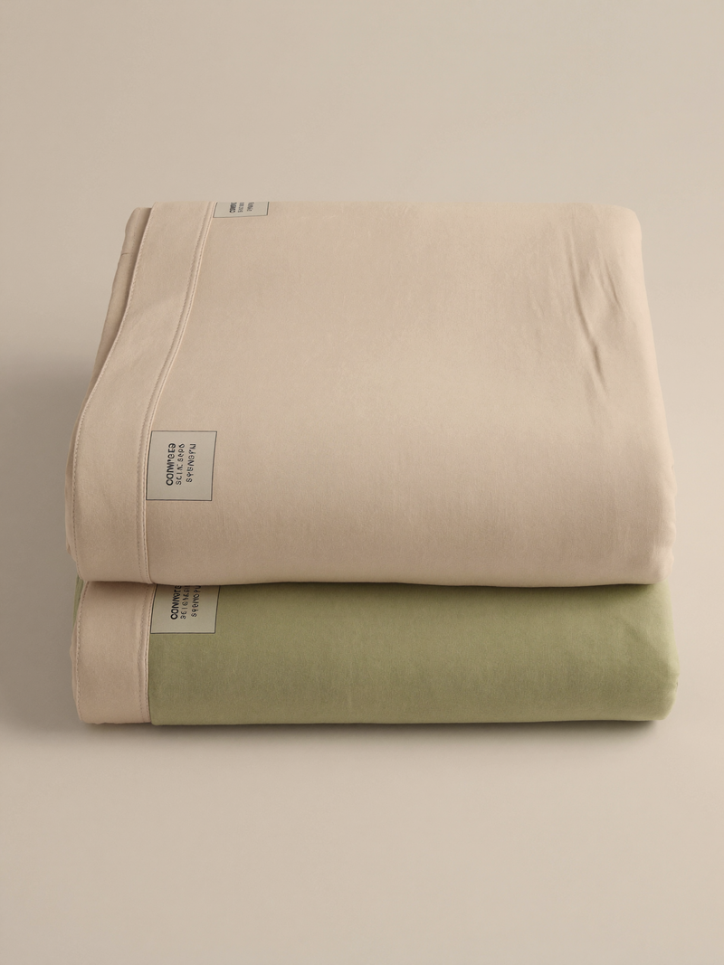 PLACEHOLDER (AI-generated) - Two folded crib sheets on cream