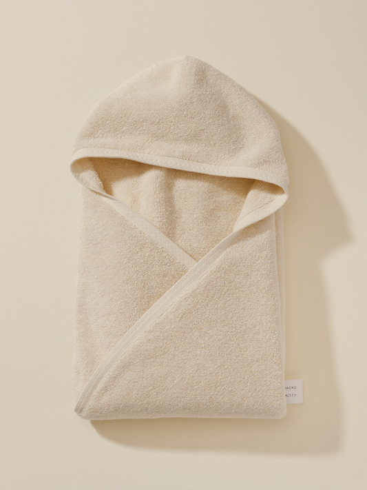 PLACEHOLDER (AI-generated) - Folded cream hooded baby towel on cream