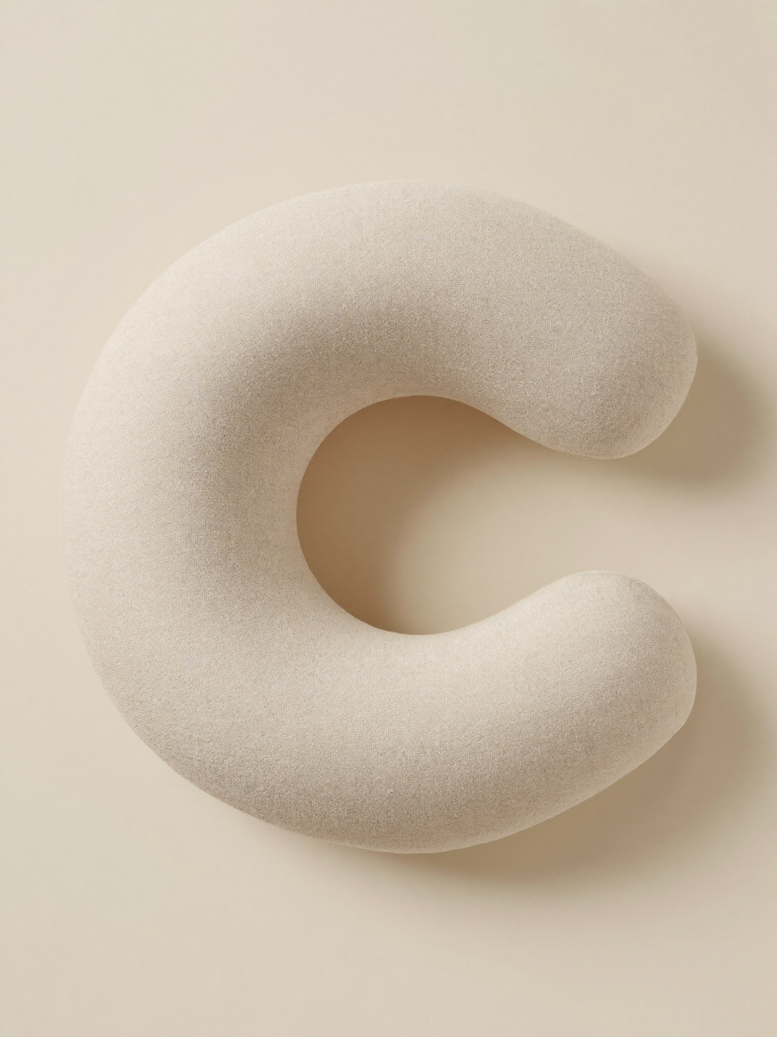 PLACEHOLDER (AI-generated) - Cream C-shaped nursing pillow on cream
