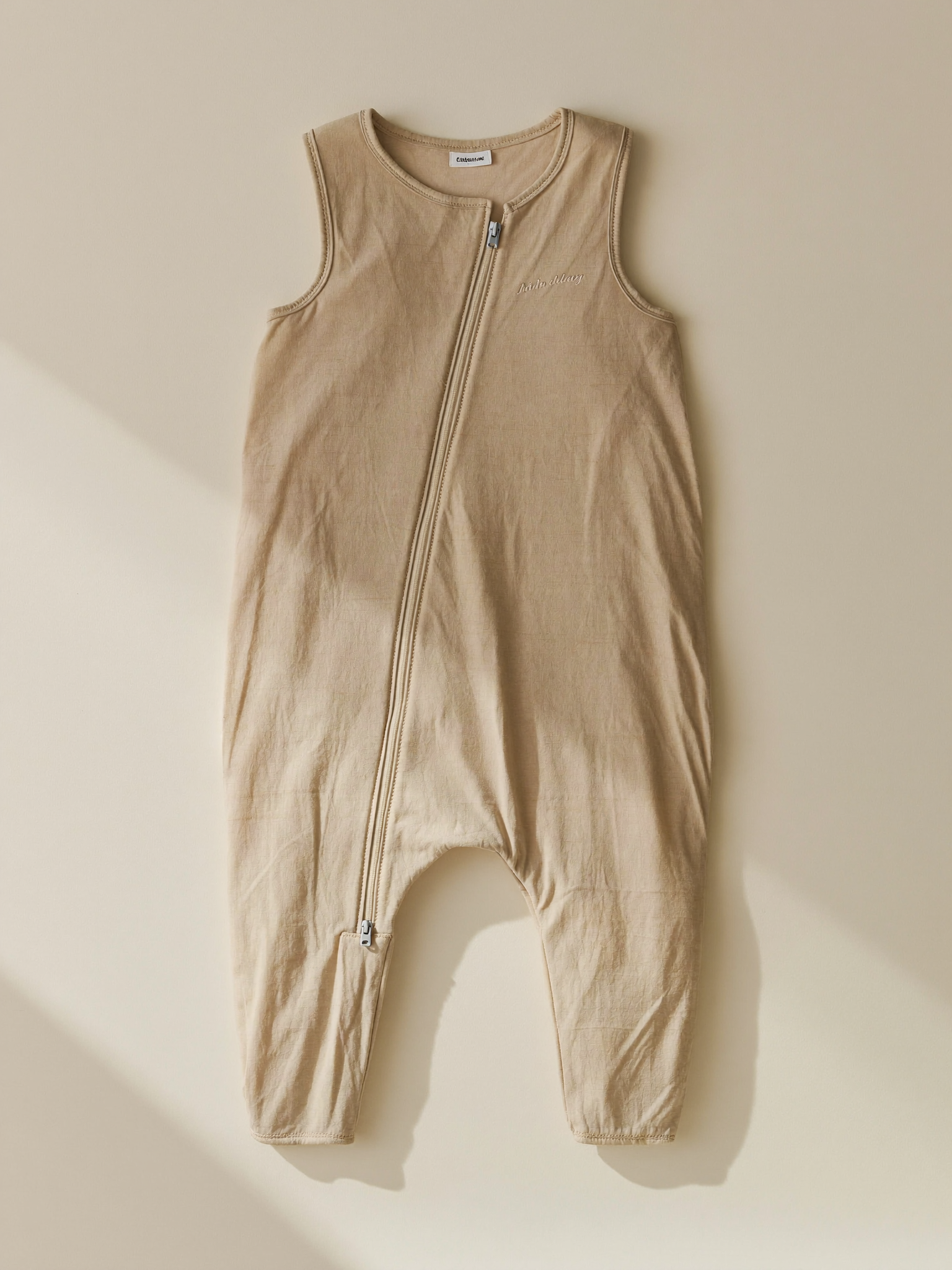 PLACEHOLDER (AI-generated) - Cream baby sleep bag laid flat on cream